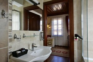 A bathroom with a white sink, mirror, and tiled walls. - CICERONE LODGE HOTEL (Antalya)