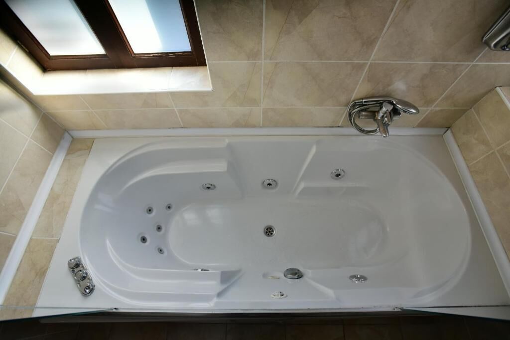 A modern bathroom with a freestanding bathtub, a skylight, and a shower area.