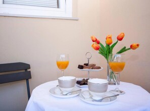 A breakfast setup with orange juice, a bowl of soup, and a small plate of cookies. - Guest House Stay & Smile Dolac Primošten (Primosten)