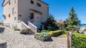 A two-story building with a staircase leading to the entrance, surrounded by greenery and a clear sky. - Guest House Stay & Smile Dolac Primošten (Primosten)