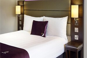 A hotel room with a large bed, two wall-mounted lamps, and a nightstand. - Premier Inn Dublin City Centre (Dublin)