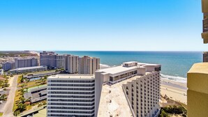 Ein Hochhotel mit vielen Etagen, Blick auf den Strand und blauem Himmel.