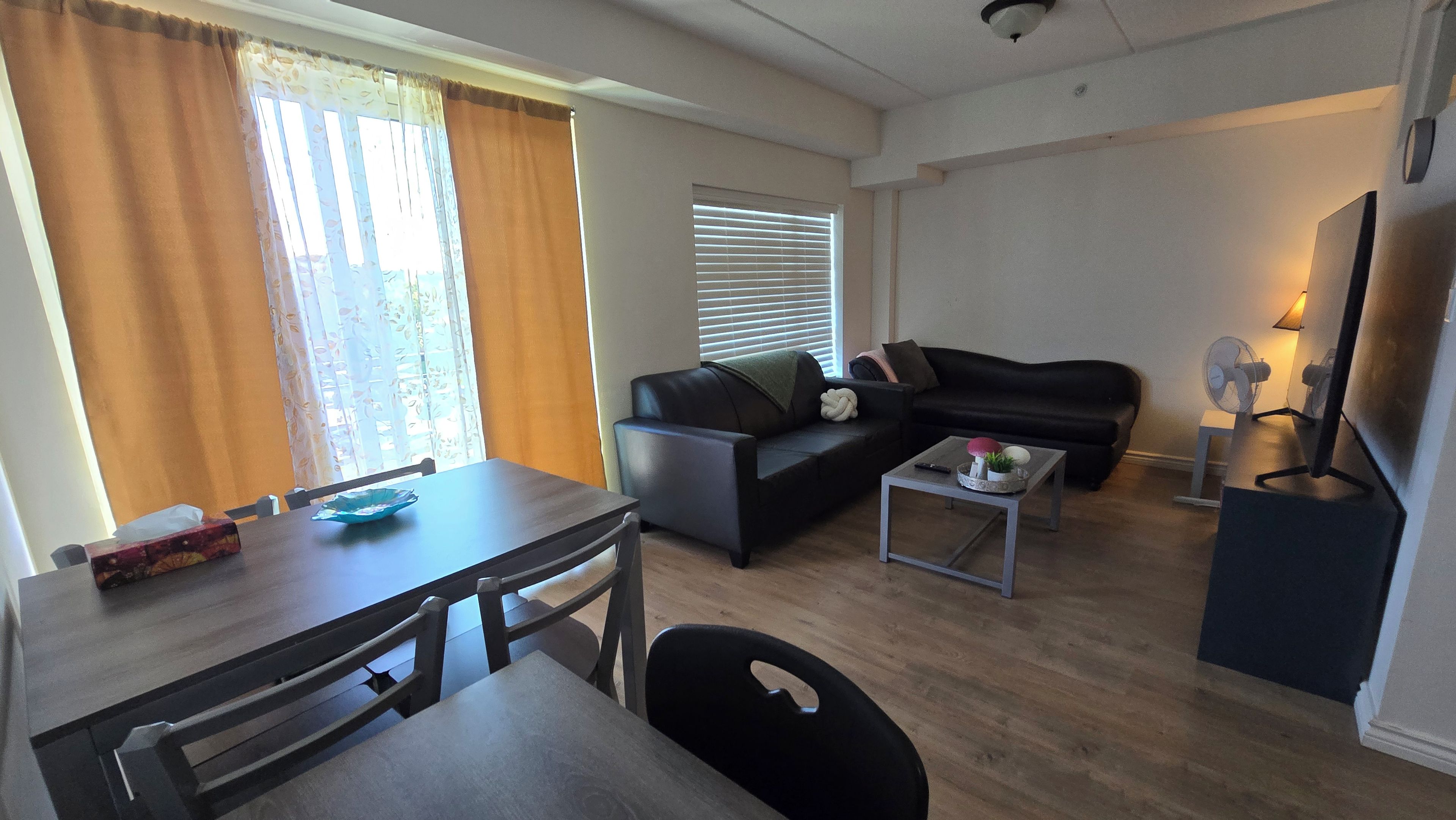 A compact living space with a dining table, sofa, and a small coffee table.