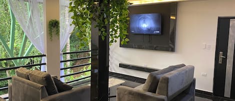 Um interior moderno com um sofá, uma TV e uma planta.