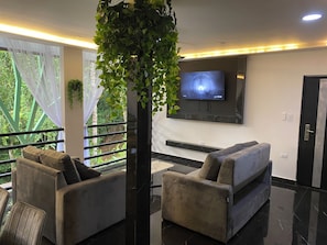 Un intérieur moderne avec un canapé, un téléviseur et une plante.