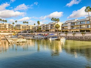 A marina with boats, a waterfront hotel with balconies, and palm trees. - Riverfront Marina Retreat with Pool! (Bullhead City)