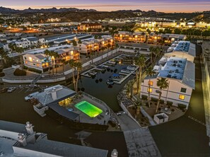 An aerial view of a resort with multiple buildings, a marina, and a pool.