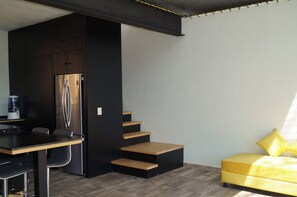 A compact living space with a kitchenette, a dining area, and a sofa. - Beautiful Loft – Forest – Lake View – Jacuzzi (san gaspar)