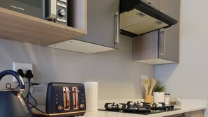 A modern kitchen with a built-in toaster, kettle, and gas stove. - Cozy 1-bed in Midrand (Johannesburg)