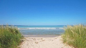 A beach path leading to the ocean with clear skies. - NEW! Dune and Drift at Crystal Beach 10 (Glen Arbor)