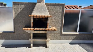 A stone-built outdoor oven structure on a rooftop patio with a tiled floor. - Vacation home with barbecue, great access to Porto (Alfena)