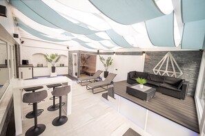 Un interior moderno con zona de bar, asientos y una pared de acento de piedra.