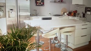 A modern kitchen with a central island, bar stools, a water dispenser, and a refrigerator. - Air-conditioned villa with pool and jacuzzi, toulon ouest (Toulon)