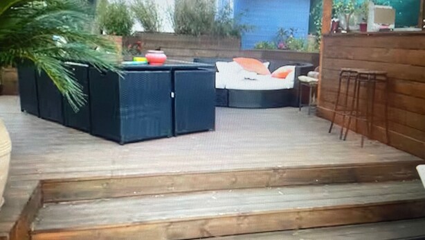 A wooden deck with outdoor seating, steps leading up to a patio area, and a blue wall in the background. - Air-conditioned villa with pool and jacuzzi, toulon ouest (Toulon)