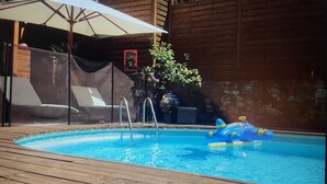 A wooden deck with a swimming pool, a lounge chair, and a covered area with an umbrella. - Air-conditioned villa with pool and jacuzzi, toulon ouest (Toulon)