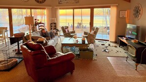 Een gezellige woonkamer met een groot raam, een televisie en een open haard.