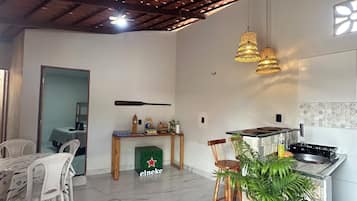 Uma sala de estar espaçosa com cozinha, mesa de jantar e cadeiras.