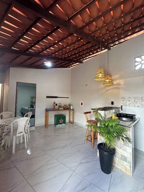 A spacious living area with a kitchen, dining table, and chairs.