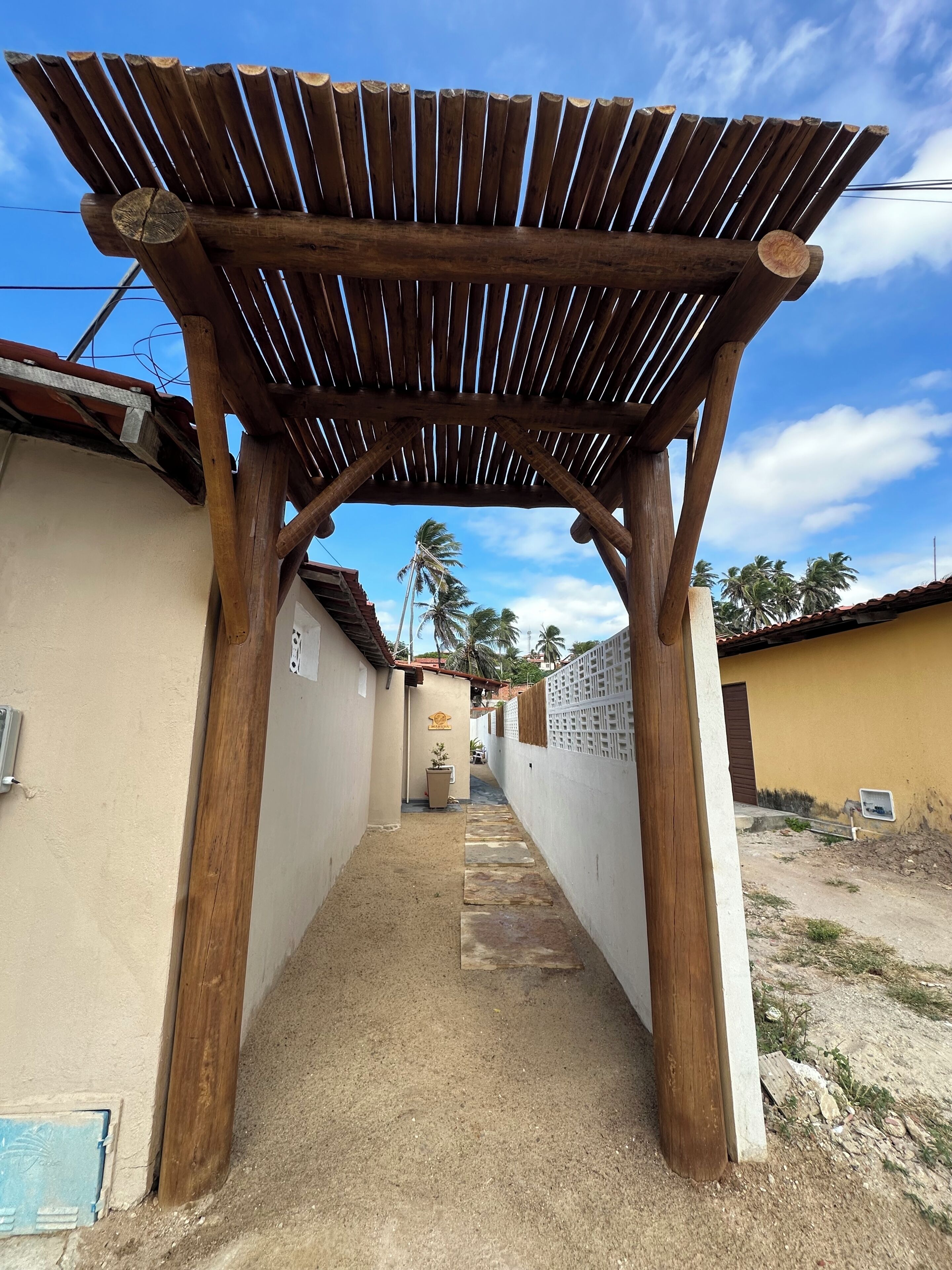 Um beco estreito com uma estrutura de pérgola de madeira.