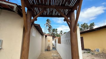 Um beco estreito com uma estrutura de pérgola de madeira.