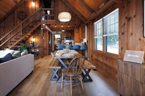 A wooden interior with a dining table, chairs, a sofa, and a staircase. - Views • Hot Tub • Fenced Yard • Near Downtown (Blue Ridge)