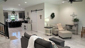 A modern living room with a grey sofa, a coffee table, a side table with a lamp, a grey armchair, and a white cabinet. - Spacious 4-bedroom, 3-bath, 2-story house in the town of Wellston, Oklahoma (Wellston)