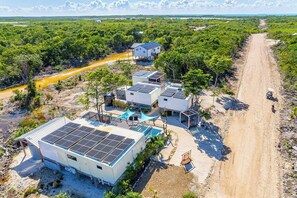 Ein abgelegenes, umweltfreundliches Resort mit Solaranlagen, einer unbefestigten Straße und üppiger tropischer Vegetation.