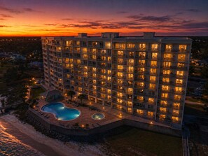 A multi-story hotel with a pool area, surrounded by a landscaped garden. - HP301 Waterfront Views, Pool, Hot Tub & Dock (Pensacola)