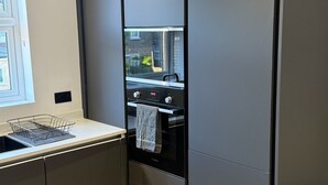 Eine moderne Küche mit Einbauofen, Fenster und Spüle.
