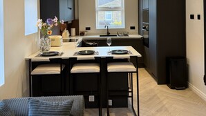 Eine moderne Küche mit einer Kochinsel, schwarzen Schränken und einem Fenster für natürliches Licht.
