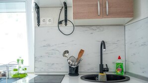 A kitchen with a white countertop, a black faucet, a green dish soap bottle, and a utensil holder. - Villa Hana in Historic Stolac (Stolac)