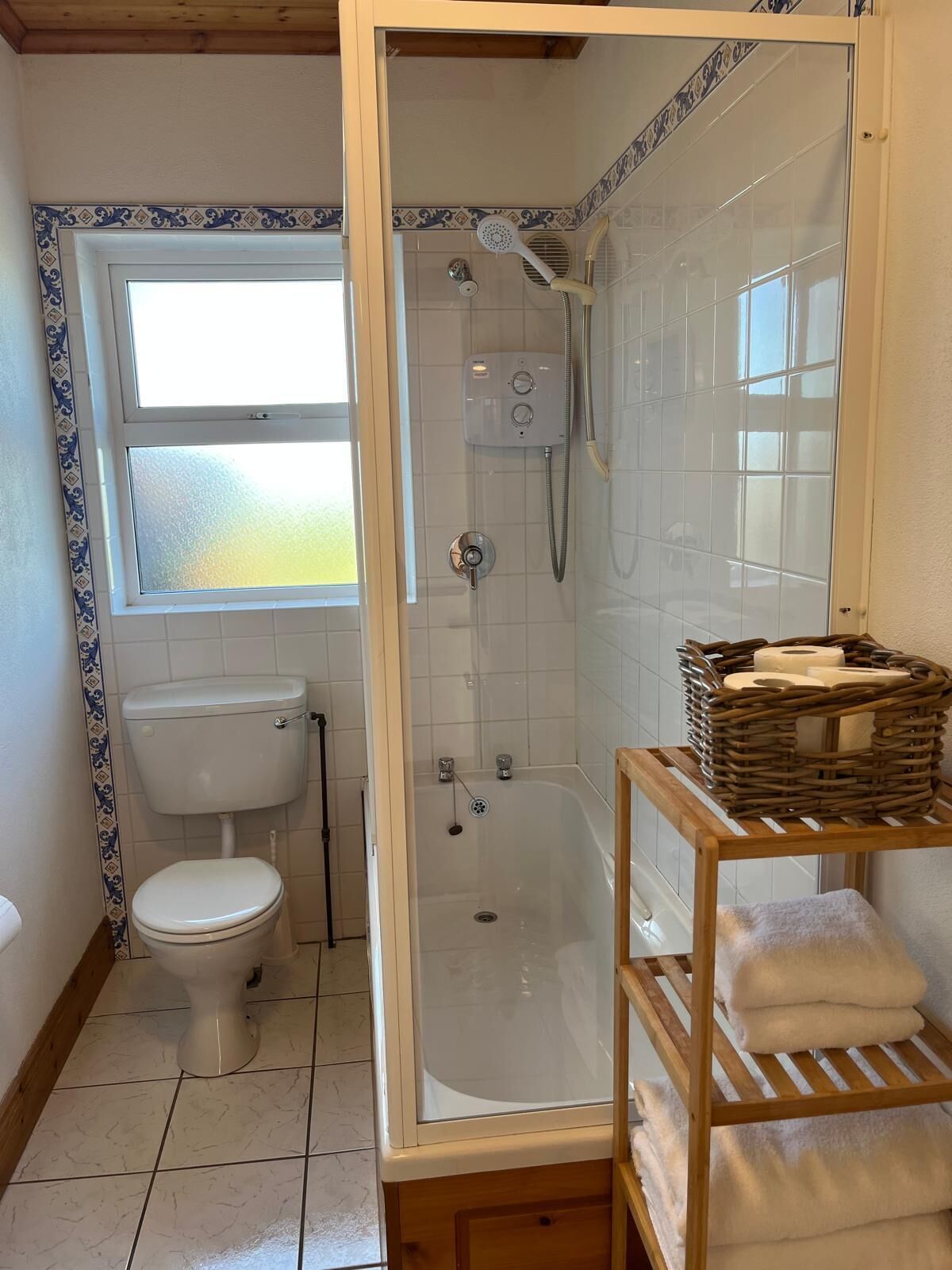 Ein Badezimmer mit Toilette, Dusche und einem Fenster.