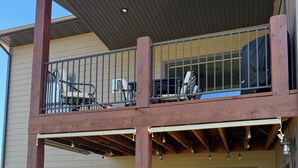 Een tweelaags huis met een balkon, buitenmeubilair en uitzicht op de bergen.