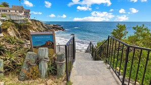 A coastal pathway leading to a beach with a sign indicating Woods Cove and a view of the ocean. - Ocean View 2BR Condo in Laguna Beach, 1-Min Walk to Beach (Laguna Beach)