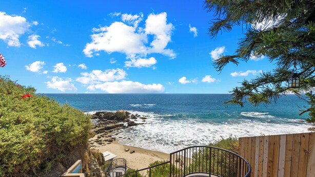 A coastal view with a wooden staircase leading to a beach, a wooden fence, and a clear blue sky. - Ocean View 2BR Condo in Laguna Beach, 1-Min Walk to Beach (Laguna Beach)