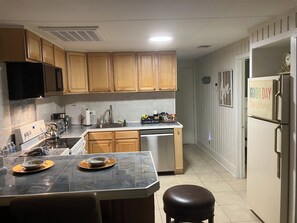 A kitchen with wooden cabinets, a stainless steel refrigerator, a coffee maker, and a microwave. - Vacation Village Resort a "Hilltop Haven" Cozy 2-bedroom cottage in Clermont (Clermont)