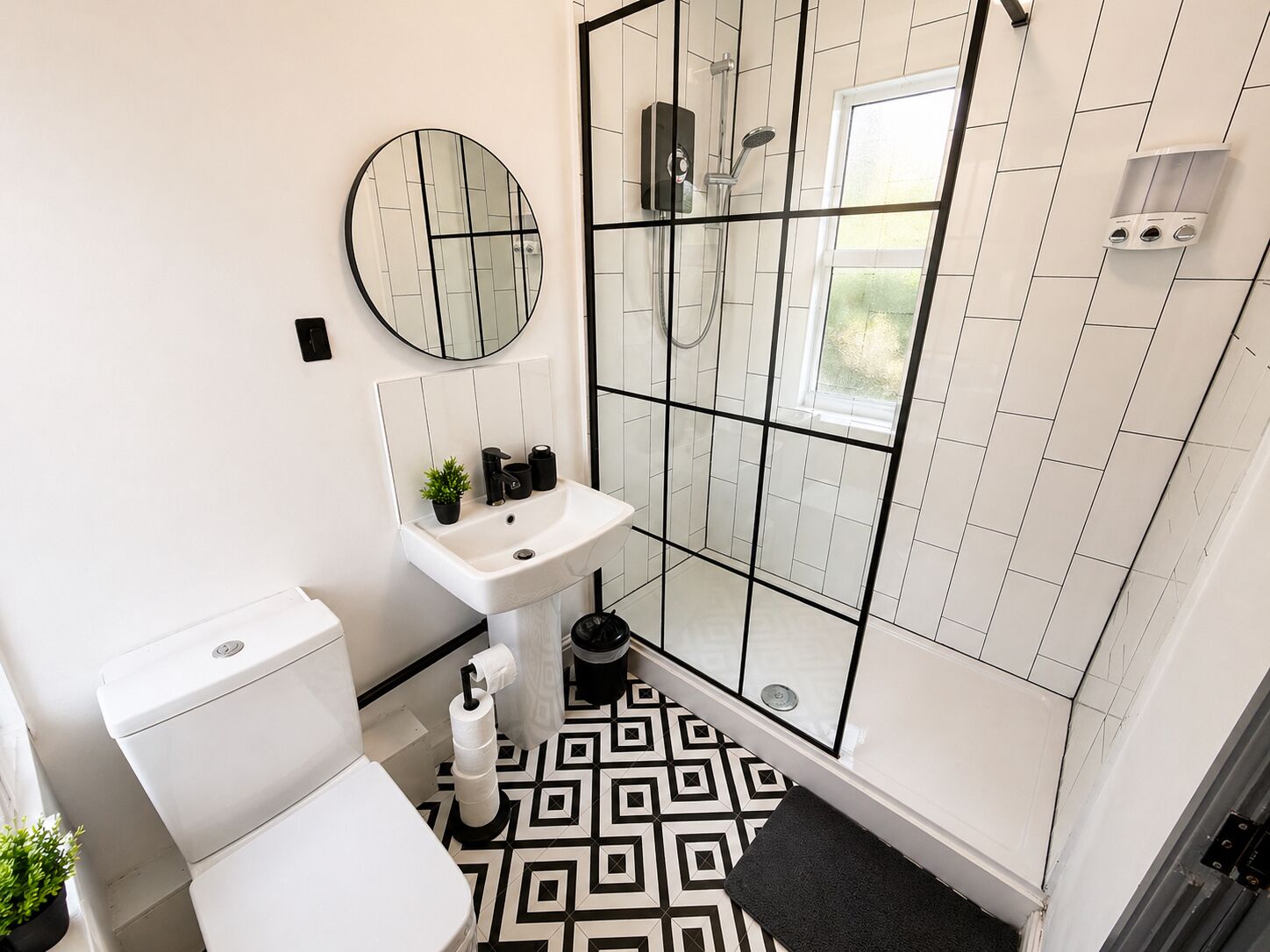 Un bagno con WC, lavandino, doccia e pavimento decorato.