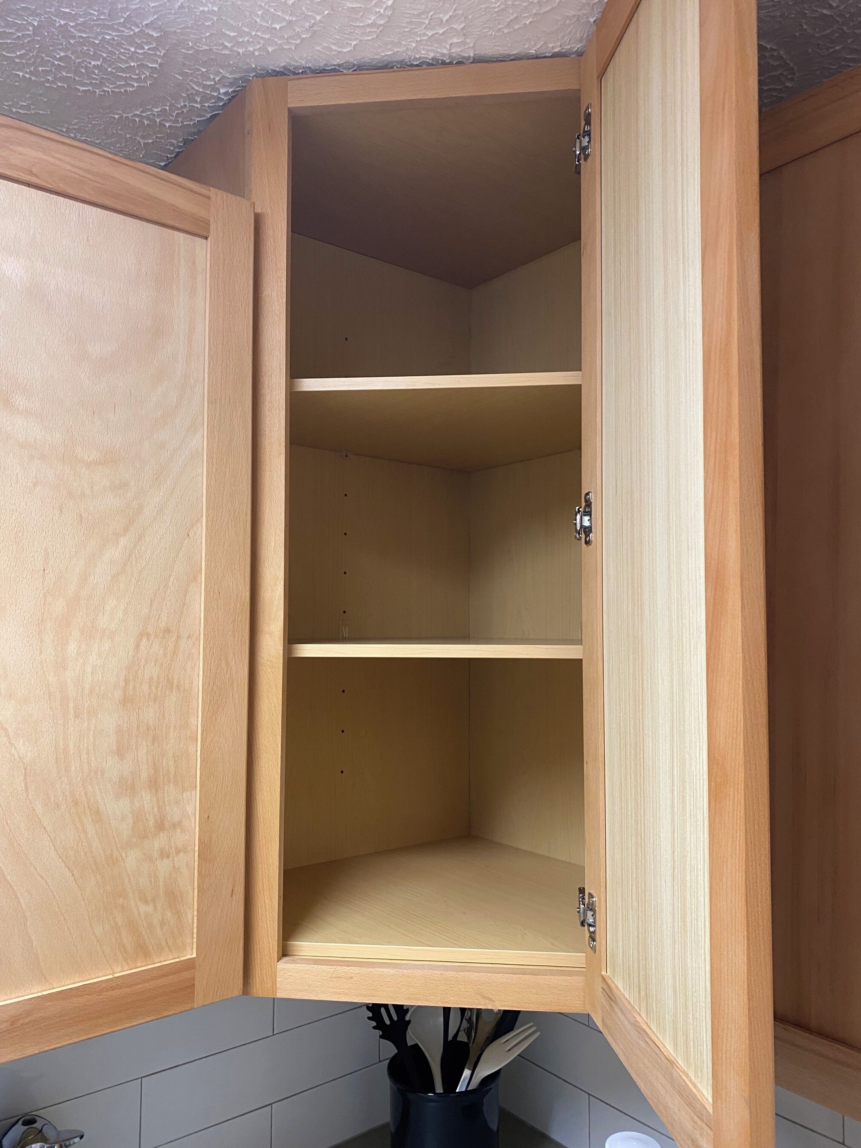 A wooden kitchen cabinet with three shelves, a handle, and a metal latch.