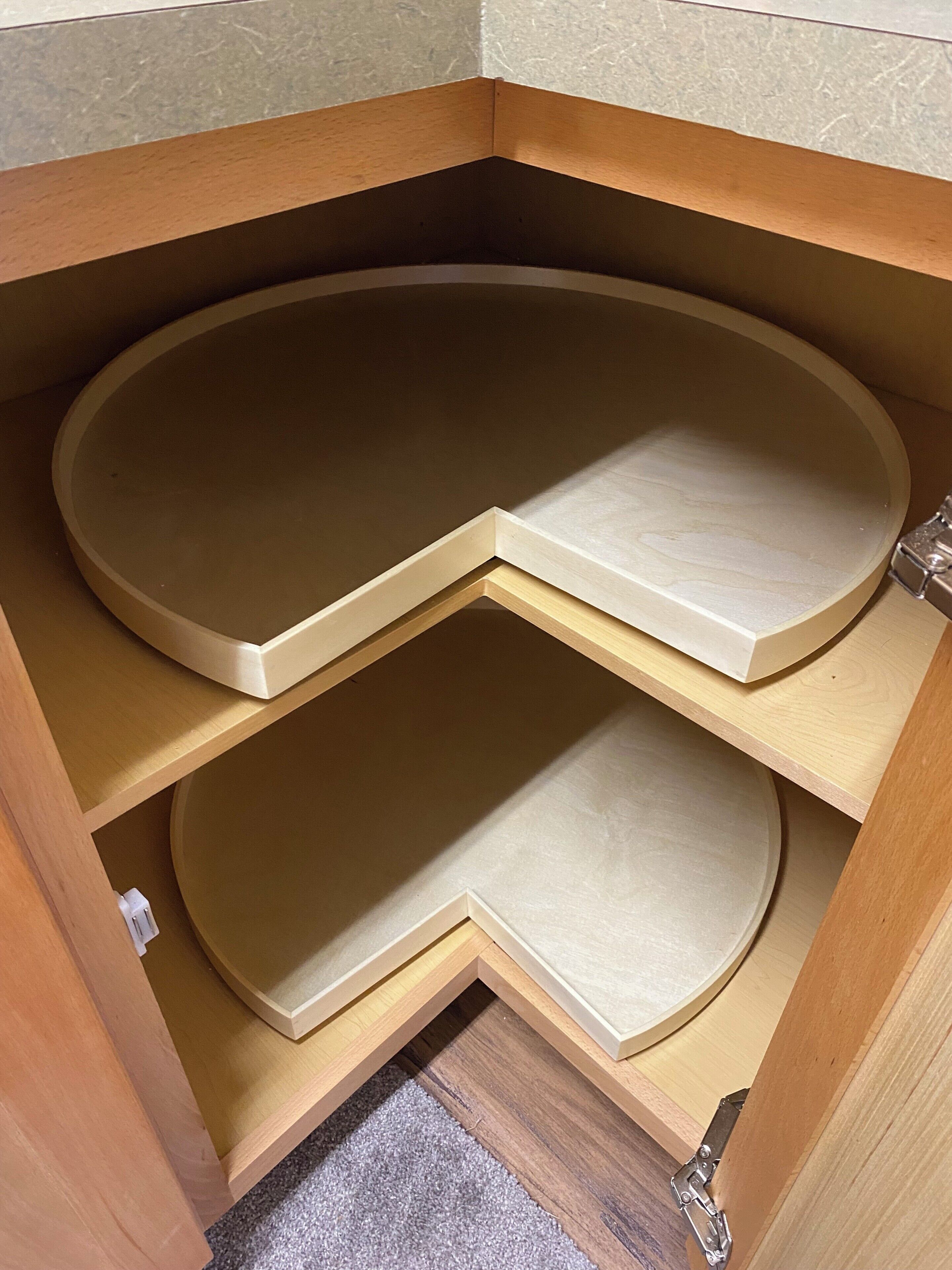 A corner of a room with built-in shelving units, a visible electrical outlet, and a carpeted floor.
