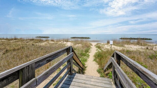 A wooden boardwalk leading to a beach with a clear sky. - Norfolk 5BR Family Home Near Ocean View Beach (Norfolk)