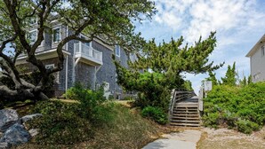 A residential area with a pathway leading to a gated entrance, surrounded by trees and shrubs. - Norfolk 5BR Family Home Near Ocean View Beach (Norfolk)