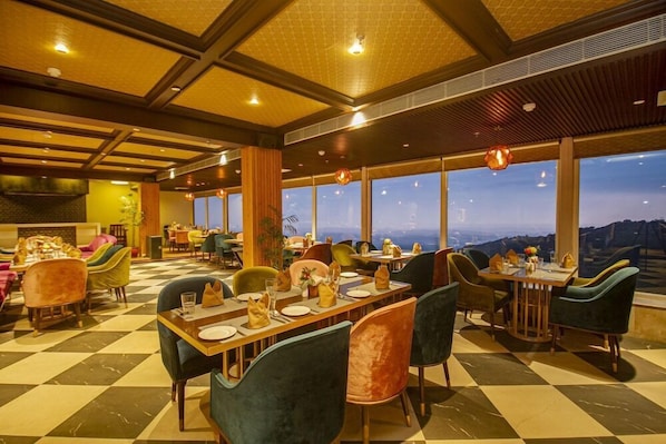 A restaurant with checkered flooring, tables set for dining, and large windows offering a view.