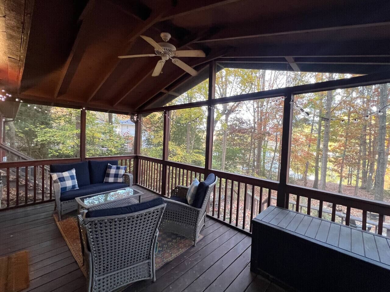 A covered outdoor area with a sofa, chairs, and a table.