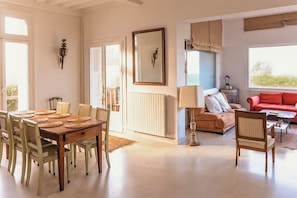 Ein Essbereich mit Holztisch und Stühlen, einer Couch, einem Couchtisch und einer Lampe.