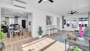 A spacious living area with a dining table, sofas, and a kitchen in the background. - Spacious Family Getaway Near AMI Beaches! Bikes, Beach Gear, Pets & Sleeps 8 (Bradenton)