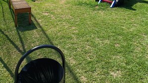 A playground with slides and climbing structures, a wooden bench, and a trash bin. - Apartment in a prime location on Coroa Vermelha beach, in a gated community. (Santa Cruz Cabrália)