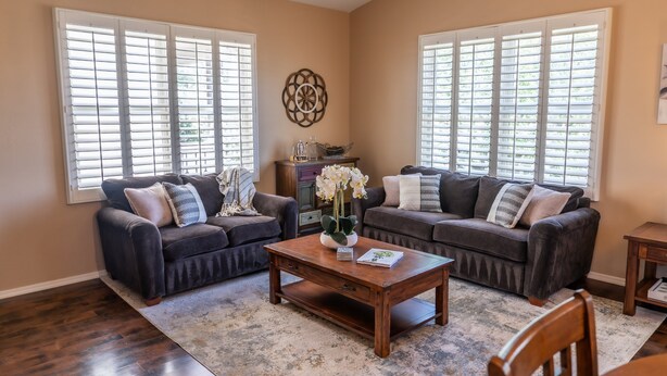 A living room with two sofas, a coffee table, and a rug. - Beautiful 3-bed 2-bath home centrally located in Gilbert with heated pool access (Gilbert)