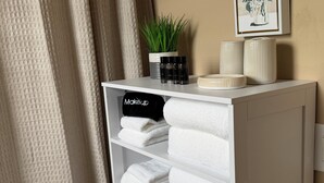 A white storage unit with shelves holding folded towels and a black towel labeled 'Makeup'. - Beautiful 3-bed 2-bath home centrally located in Gilbert with heated pool access (Gilbert)