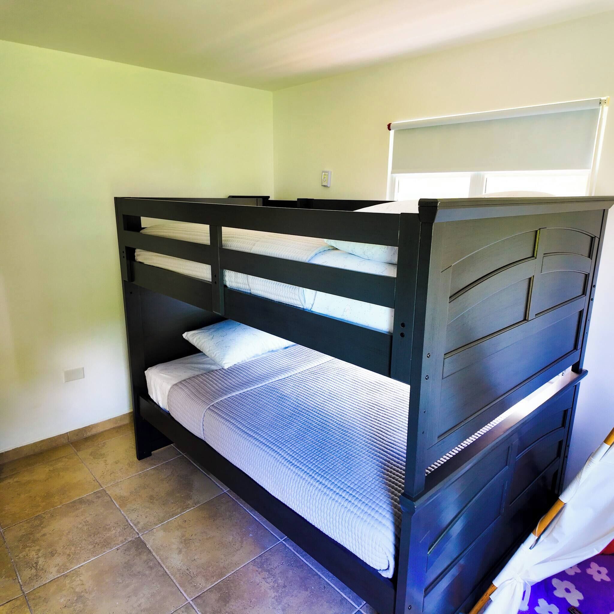 A bunk bed with a headboard, a mattress, and a pillow.