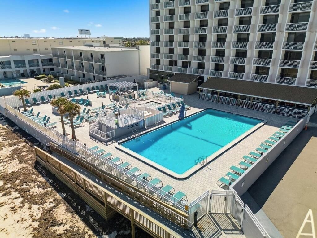Um hotel com piscina no terraço, várias varandas e vista clara da região.